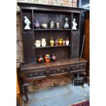 An 18th century and later oak high dresser, the dentil moulded cornice over plank backed open