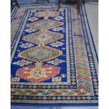 A handmade Kazak small carpet, the geometric design in dark blue on peach ground, 245 x 175 cm [