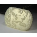 A green jade pendant of whitish hue, decorated with a boy on the obverse and a four-line inscription