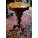 A Victorian inlaid octagonal rosewood work table with chequer board hinged top enclosing a fitted