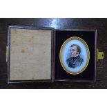 A Victorian oval miniature portrait on glass of a gentleman with sideburns, in leather pocket-case