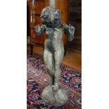 An antique weathered lead figure of a standing cherub on a rocky outcrop base  Well weathered, the