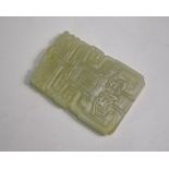 A green jade pendant of shaped, rectangular form decorated with archaic style motifs, 5cm long and