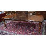 A large Victorian style mahogany dining table, the wind action top extending to accept two insert