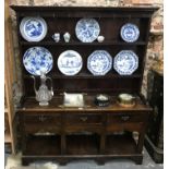 An 18th century or later oak cottage dresser, the plank back rack over a three drawer base and pot