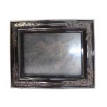 A 19th century Continental moulded tortoiseshell picture frame with floral-carved applied corners on