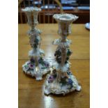 A pair of French 19th century porcelain candlesticks of scrolling rococo form with gilding and