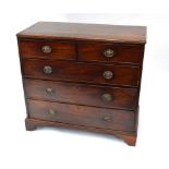 A George III mahogany chest of two short over three long graduated drawers, raised on shaped bracket