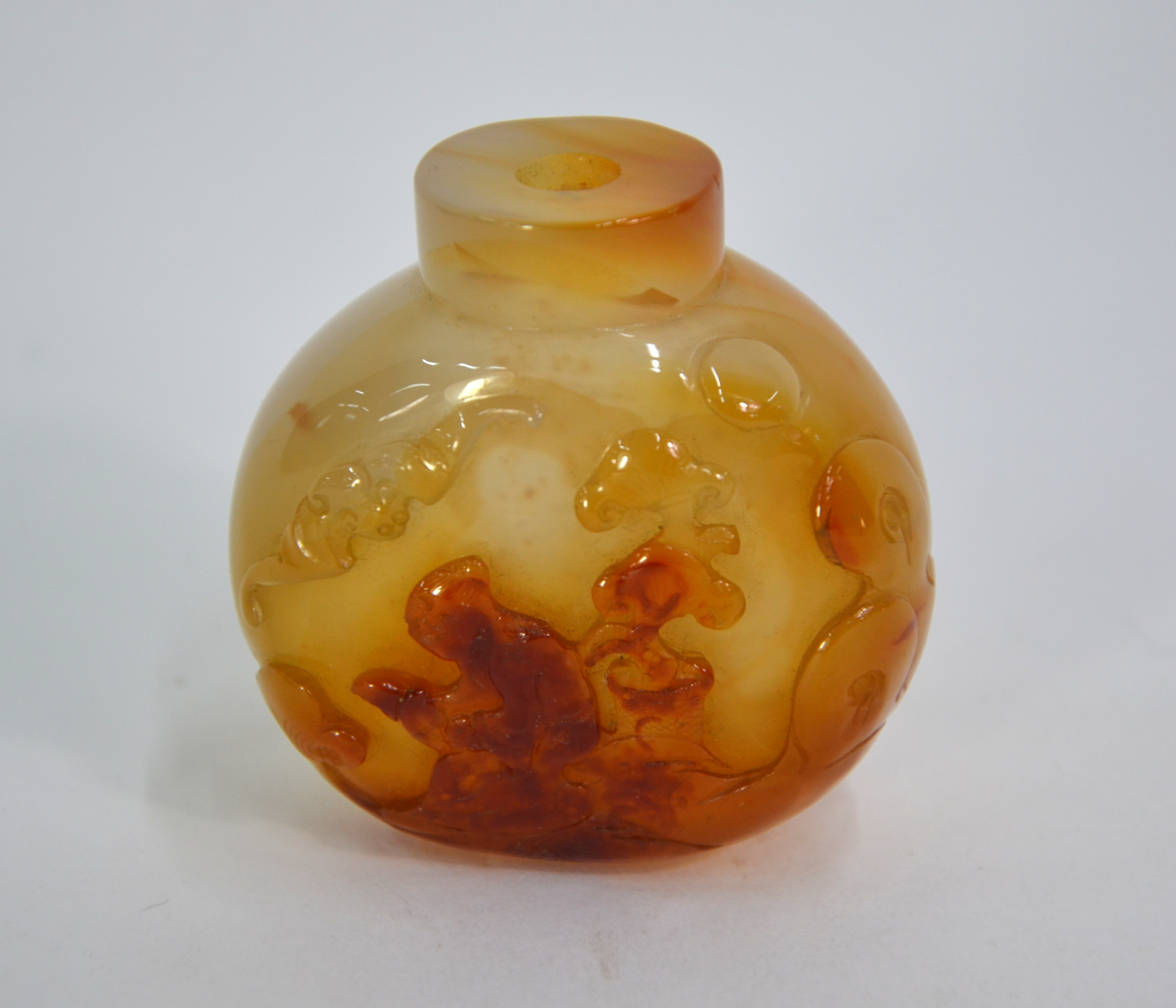 An agate Chinese snuff bottle, decorated with a scholar kneeling beneath a bat, 5.5 cm high Some