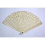 A Cantonese ivory fan with twenty sticks; decorated with typical designs of figures, gardens and