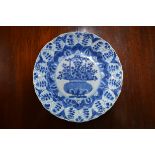 A Chinese blue and white dish, decorated with a central panel of a flower arrangement,  20.5 cm