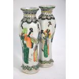 A pair of famille verte vases, each one with a ribbed body decorated with standing Manchu/Chinese