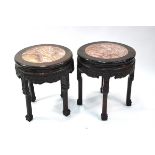 A pair of Chinese hardwood stands with circular marble, or other stone, inlaid tops; 42 cm diameter,
