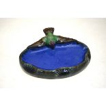 A Doulton Lambeth soap dish in the form of a blue pond surmounted by a bird with outstretched wings,
