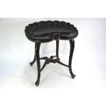 An Edwardian dark stained walnut scallop form stool