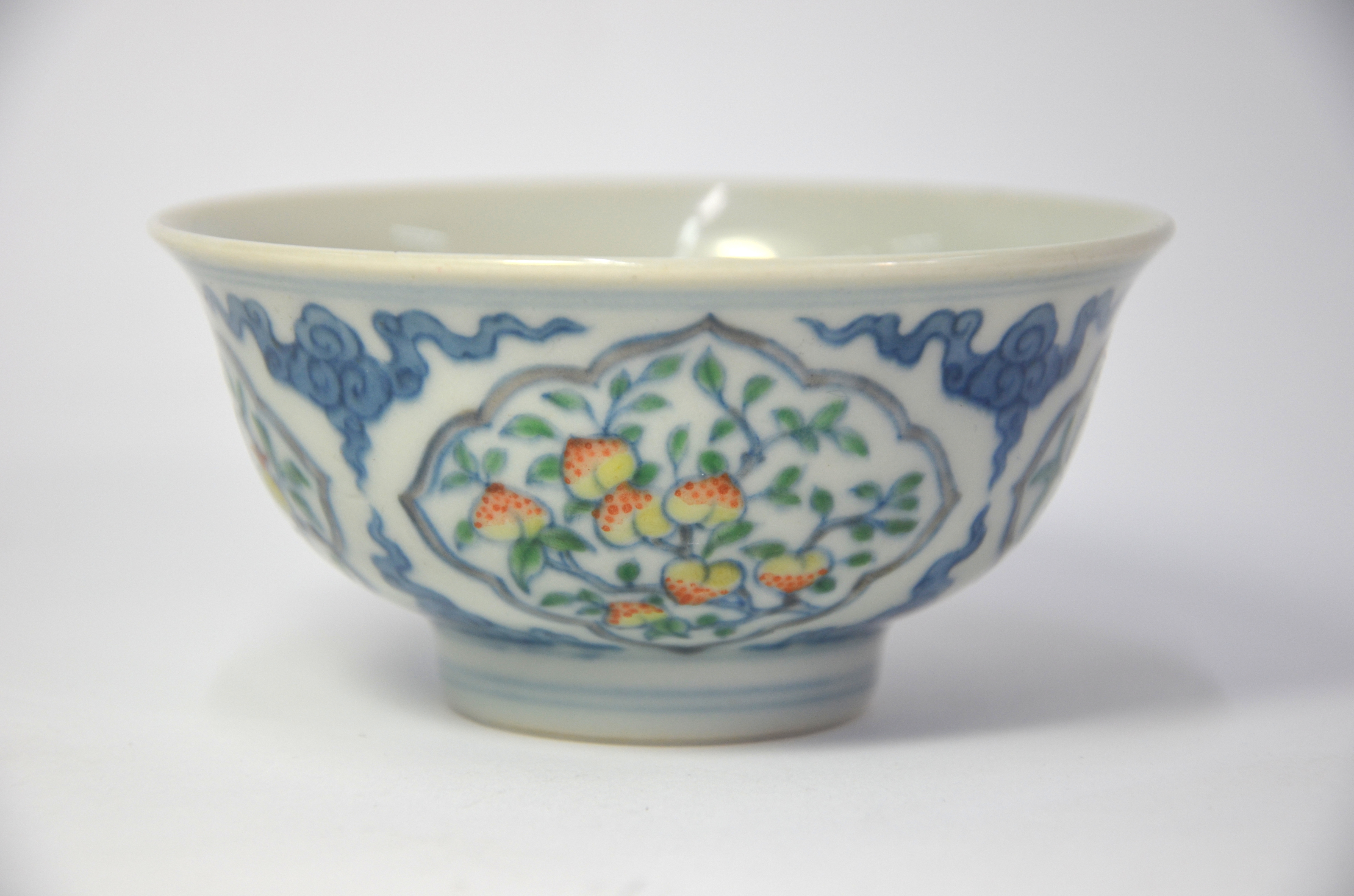 A Doucai bowl, decorated with underglaze blue cloud scrolls dividing four shaped panels of various