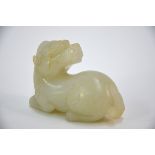 A green jade of whitish hue, carved as a recumbent Buddhist Lion, looking over its shoulder, 7.5