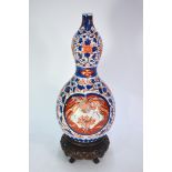 A Japanese Imari vase of gourd form, decorated in underglaze blue and typical colours  with shaped