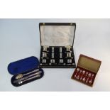 A cased twenty piece silver condiment set with blue glass liners including spoons, Birmingham 1938