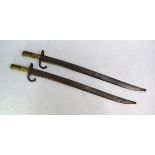 Two 19th century French bayonets with 57.5 cm recurved and fullered blades, curled guards and cast