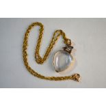 An antique rock crystal hinged heart shaped locket having rose diamond and garnet cross style