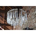 An Art Deco brass-framed three-tier ceiling lightshade with cut glass facetted baton drops