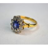 An oval sapphire and diamond cluster ring, 18ct yellow and white gold set, size Q Sapphire showing