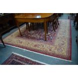 An Indian Lotti design carpet, stylised floral design with large rosettes on rust ground within a