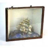 A small 19th century diorama of a three-masted ship of the Line in coastal waters, with a smaller