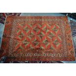 An old Turkman Yomut rug circa 1920, the repeating field of stylised flowers on mid-red ground,