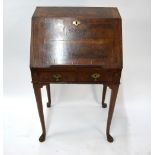 An antique feather-banded walnut bureau, the fall enclosing a well-fitted interior of drawers,