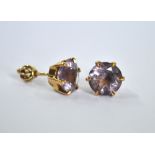 A pair of circular pale amethyst stud earrings, yellow metal claw set