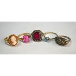 A collection of five rings including two set red synthetics, one cameo, one marcasite and one rubbed
