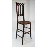 A Victorian Gothic form fruitwood correction chair, with caned seat