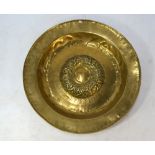 A brass alms dish with raised central boss and vestigial Gothic script - probably German, 17th