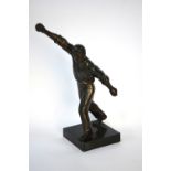 A bronzed spelter figure of a cricket bowler, 28 cm high