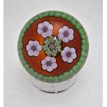 A Perthshire glass paperweight of millefiori rosette design incorporating a 'P' cane, rust ground,