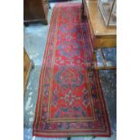 An antique Turkey carpet runner, the geometric design on red ground, 352 x 91 cm