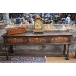 A late 17th/18th century oak low dresser, the side plank top with moulded edge over three chequer-