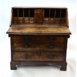 An 18th century walnut bureau, the fall enclosing a fitted interior over four long graduated