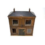 A large 19th century double fronted wooden doll's house, the twin hinged front centred by a fixed