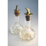 Two cut glass bitters bottles, the silver stopper-spouts cast with a pheasant head and a gilt