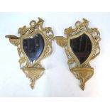 A pair of Rococo style painted wood wall mirrors with bevelled shield plates