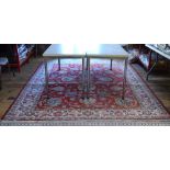 An antique Persian Tabriz carpet, the repeating floral design on red ground, 339 x 238 cm