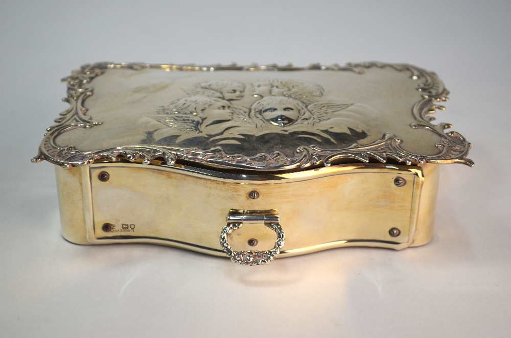 A silver jewellery box of serpentine form, the scroll-edge top embossed with winged cherub-heads, - Image 2 of 7