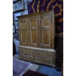 An antique stripped and waxed pine housekeeper's cupboard in two parts, the upper part with three