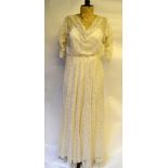 A late 19th century ivory needle-run lace wedding dress with cowl neck, ruched sleeves and ivory