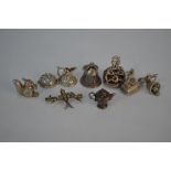 A collection of seven charms, one stamped silver, to/w bird brooch set white paste
