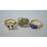 Collection of three rings including diamond crossover cluster ring, white paste, and three stone