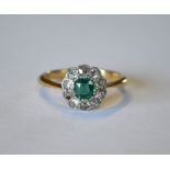 An emerald and diamond cluster ring, yellow and white metal millgrain setting stamped 18ct, size K
